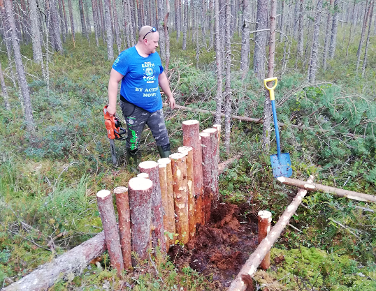 Heikki Susiluoma seisoo paaluista rakennetun padon vierellä.